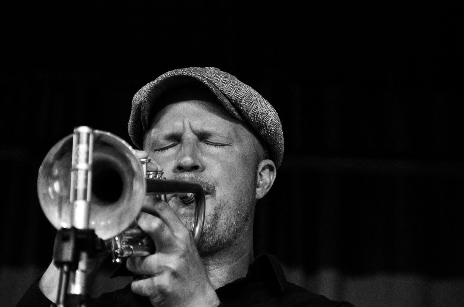 man playing the trumpet in a black and white image